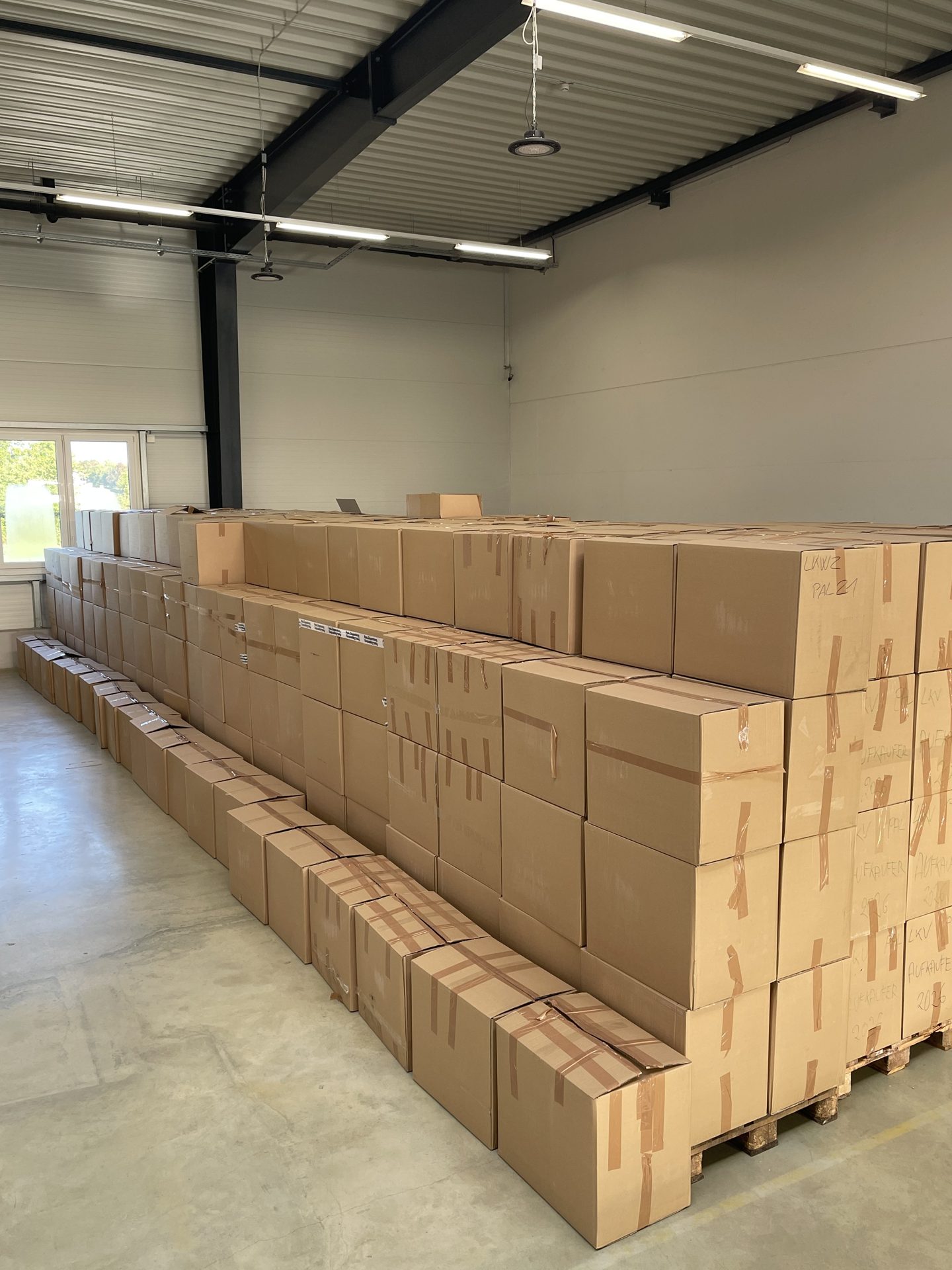 A long perspective of palletized cartons inside the warehouse
