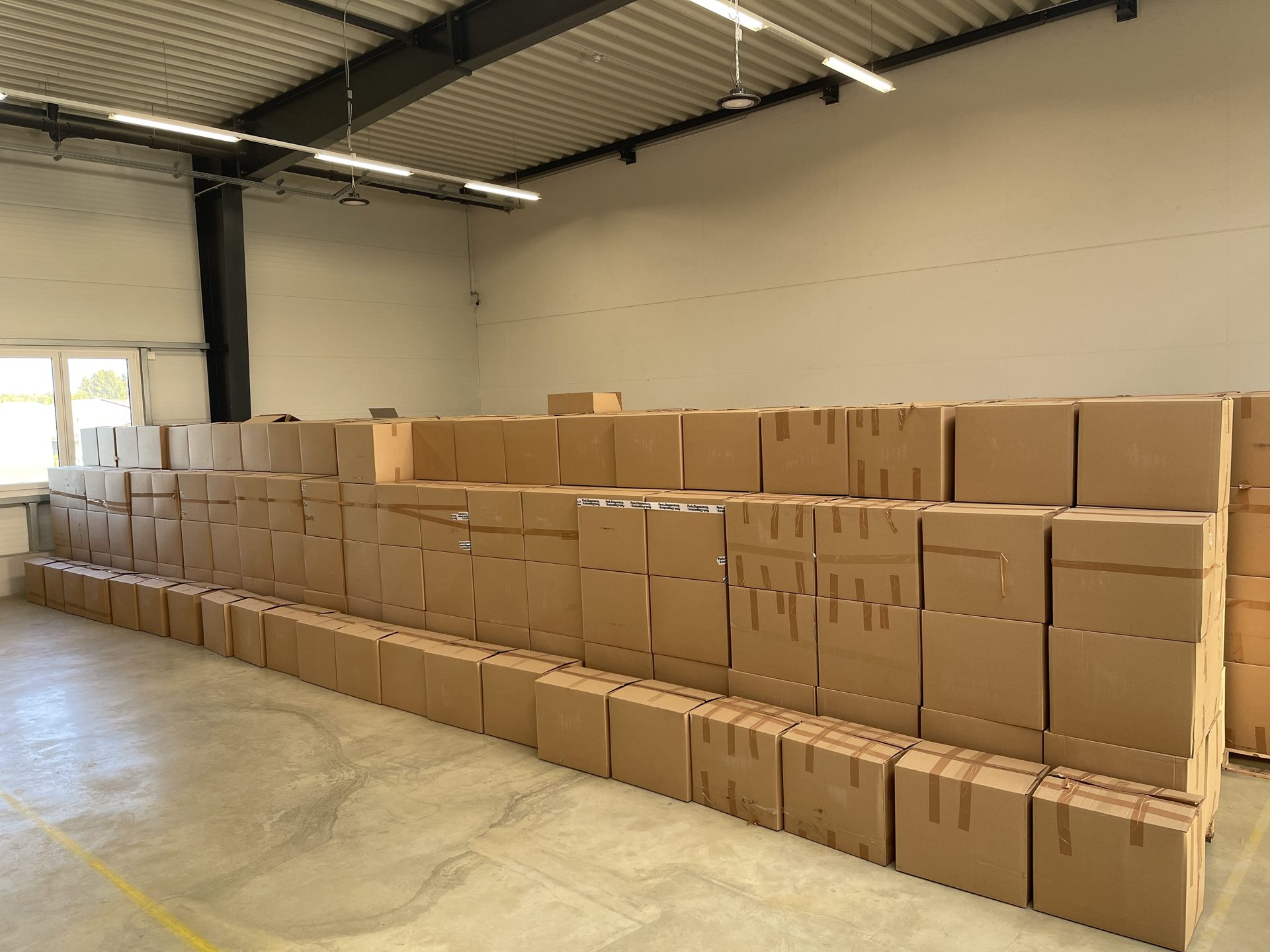 Long rows of cardboard cartons across the warehouse floor